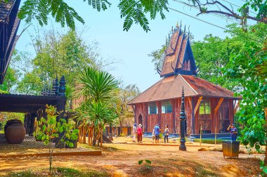 CHIANG RAI, THAILAND - 11 Mayıs 2019: 11 Mayıs 'ta Chiang Rai kompleksinde tahta kertenkele evi kompleksi, karmaşık gable çatı ve oyulmuş chofa süslemeleri ile etkileyici bir dış görünüş