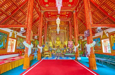 CHIANG RAI, THAILAND - 11 Mayıs 2019: Wat Phra Singh Tapınağı 'nın iç mimarisi kırmızı-yaldızlı duvarlar, sütunlar ve ünlü Phra Sihing (Phra Singh) Buda resimlerinin kopyaları 11 Mayıs' ta Chiang Rai 'de sunakta