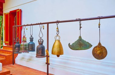 Wat Phra Kaew Tapınağı 'nın avlusundaki Kyizi gong, Chiang Rai, Tayland' daki asılı ortaçağ çanları ve gongları.