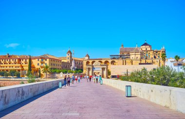 CORDOBA, SPAIN - SEP 30, 2019: Antik Roma Köprüsü 'nde yürüyün ve Mezquita-Katedral, Puerta del Puente kapısı, Episcopal Sarayı ve Guadalquivir Nehri' ni izleyin.