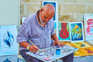 CORDOBA, SPAIN - 30 Eylül 2019: Sanatçı 30 Eylül 'de Cordoba' da Arap kaligrafi tekniğinde siyah mürekkep ve qalam kamış kalemi ile yazı hazırladı.