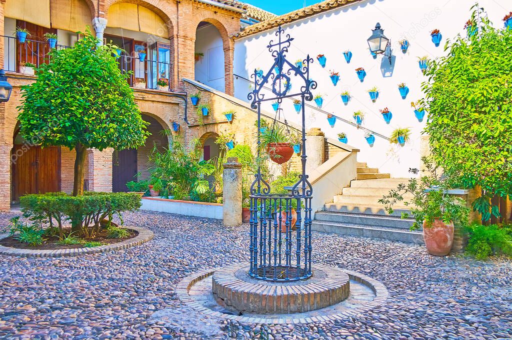 The Cordovan Patio of  Aca Zoco municipal handicraft market is decorated by bright blue pots with plants and flowers, Cordoba, Spain