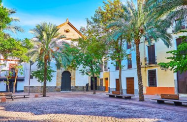 Küçük ve gölgeli Plaza de las Canas 'ta bereketli palmiye ağaçları, banklar ve Piedad Koleji' nin tarihi binaları, Cordoba, İspanya