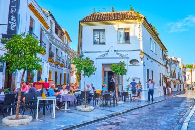 CORDOBA, SPAIN - 30 Eylül 2019: 30 Eylül 'de Cordoba' da Cardenal Gonzalez Caddesi 'nin manzaralı beyaz evleri arasında rahat bir açık hava restoranı