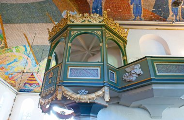OSLO, NORWAY - SEP 28, 2010: The carved wooden pulpit in Oslo Cathedral with gilt garlands and wall sculptures of angels, on Sep 28 in Oslo
