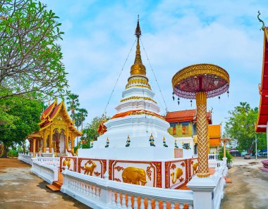 The chedi (stupa), chatra ceremonial umbrella and the viharn hall of Wat Sangkharam Temple (Pratu Lee), Lamphun, Thailand clipart