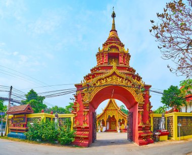 Wat Sangkharam Tapınağı 'nın güzel kırmızı kapısı kabartma kalıplar, Naga yılanları, Buda heykelleri ile süslenir ve üzerinde küçük çadırı, Lamphun, Tayland