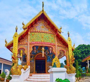 Parlak mozaikleri, yaldız desenleri, Naga yılanları heykelleri ve pyathat (gable) çatısı, Lamphun, Tayland