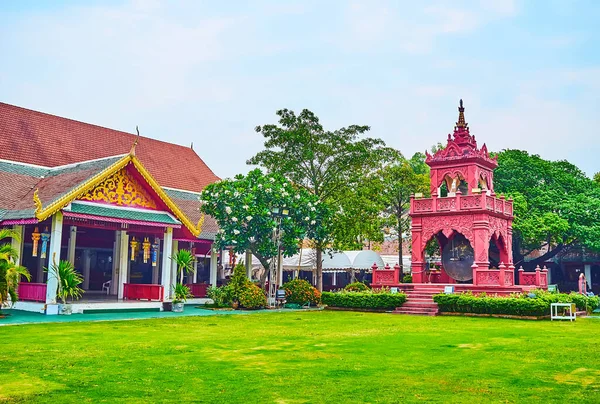 在位于泰国楠榜的华府海风寺 Wat Phra Hariphunchai Temple 的风景秀丽的绿色花园漫步 观摩何乐康礼仪钟楼的红色旧楼 — 图库照片