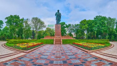 Taras Shevchenko Park panoraması Shevchenko heykeli, yemyeşil ağaçlar ve parlak lale çiçekleri, Kyiv, Ukrayna
