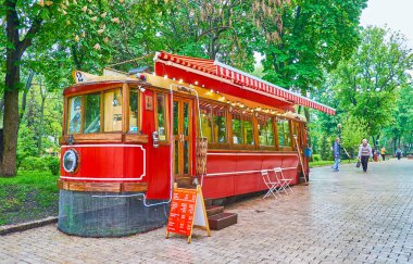 KYIV, UKRAINE - 18 Mayıs 2021: 18 Mayıs 'ta Kyiv' de Taras Shevchenko Parkı 'nda yer alan sokak barı, kahve evi, hediyelik eşya ve kitap dükkanı olarak hizmet veren klasik kırmızı tramvay