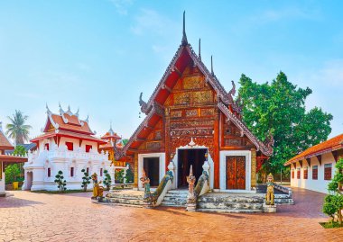 Ho Trai kütüphanesinin beyaz binası ve Wat Pratu Pong 'un büyüleyici Viharn' ı oyulmuş ahşap ve efsanevi yaratıklarla süslenmiş, Lampang, Tayland