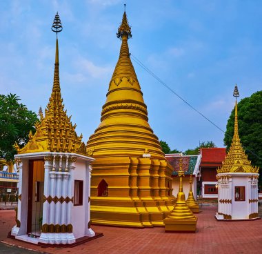 Wat Koh Walukaram Tapınağı 'nın pitoresk altın çadırı, küçük stupalar ve mondop türbeleriyle çevrili, Lampang, Tayland