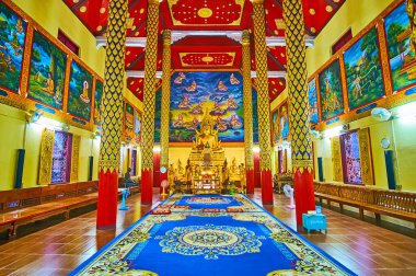 LAMPANG, THAILAND - 8 Mayıs 2019: Wat Suan Dok Viharn 'ın sunağında altın Buda ve duvarlarında birçok duvar resmi olan renkli iç mekanı, 8 Mayıs' ta Lampang 'da