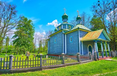Çitin arkasında Pereiaslav Scansen, Ukrayna 'daki kilisenin yanında bulunan küçük bir mezarlığı olan tarihi şefaat kilisesi cephesi.