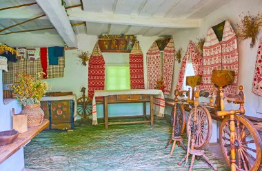 PEREIASLAV, UKRAINE - 22 Mayıs 2021: 22 Mayıs 'ta Pereiaslav Scansen, Pereiaslav' da dönen tekerlekler ve nakışlı rushnyk havlularıyla küçük dulun evinin içi