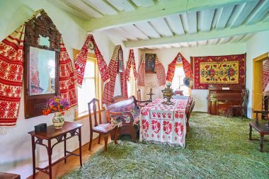 PEREIASLAV, UKRAINE - 22 Mayıs 2021: Pereiaslav Scansen 'de 22 Mayıs' ta Pereiaslav Scansen 'de zengin köylünün hata evinin işlemeli ahşap havluları ve ahşap mobilyaları ile yemek odası