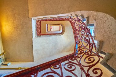 Manzaralı metal tırabzanlar, Odessa, Ukrayna 'nın klasik spiral merdiven boşluğunun yukarı bakan manzarası.