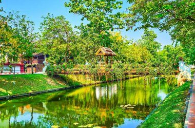 Walk along the medieval moat with niice small footbridges, decorated with wooden gate and hanging plants, Chiang Mai, Thailand