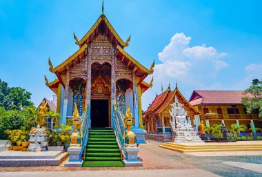 The medieval facade of the viharn of Wat Thung Yu, decorated with Naga serpent sculptures along the staircase, stone-teakwood columns, wooden gabel end and carved roof, Chiang Mai, Thailand