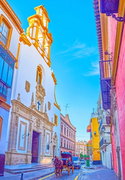Tarihi Santa Cruz Kilisesi 'nin mütevazı cephesi ile dar bir sokak tepesinde çan gable, Seville, İspanya