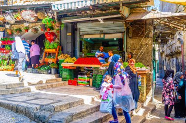 JERUSALEM, ISRAEL - 16 Şubat 2016: Çarşı Han El-Zeit pazarının gürültücü tüccarları 16 Şubat 'ta Kudüs' te taze çilek, muz ve bezelye fiyatları hakkında haykırıyorlar.