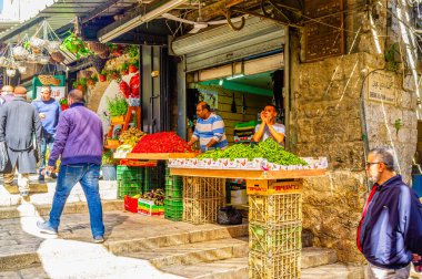 Kudüs, İsrail - 16 Şubat 2016: Tüccar ve oğlu 16 Şubat'ta Kudüs'te Şam Kapısı'ndaki Arap çarşısında çilek ve yeşil bezelye satıyor.