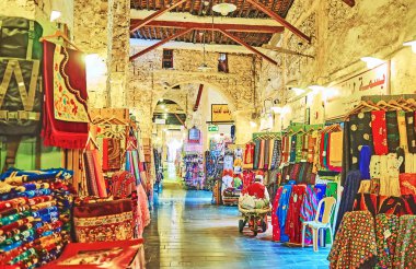Doha, Katar - 13 Şubat 2018: Renkli kumaşlar, halılar ve halılar Souq Waqif - kapalı sokakta geniş geleneksel Doğu Pazar eski şehirde, Şubat 13 Doha