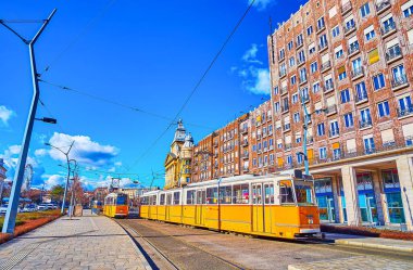 BUDAPEST, HUNGARY - 22 Şubat 2022, Budapeşte 'de 22 Şubat' ta Deak Ferenc Meydanı 'nın yanındaki Karoly Caddesi' nden geçen klasik sarı tramvaylar