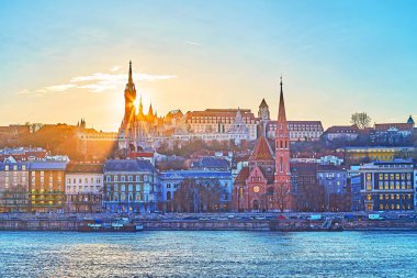 Silhouette of Fisherman's Bastion behind Danube River at golden sunset, Budapest, Hungary