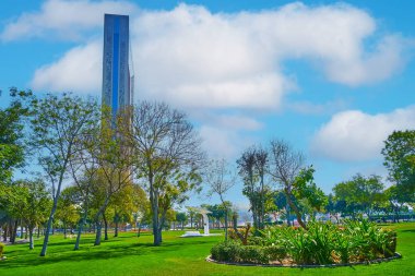 Zabeel Park 'ın güzel yeşil bölgesi sık sık gölgeli ağaçlar, çiçek yatakları ve Dubai Frame, Dubai, BAE manzaralı bir piknik alanı olarak kullanılır.