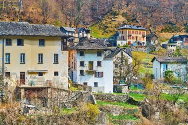 İsviçre Vallemaggia 'daki Prato Sornico köyünün klasik konutlarına sahip dağ ayağı.