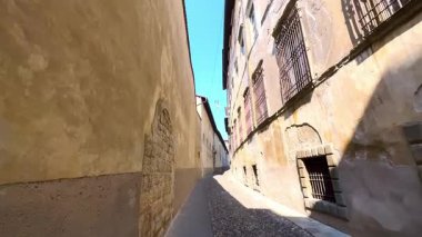 Bergamo, Lombardy, İtalya 'nın Yukarı Şehir (Citta Alta)' de bulunan Via Arena caddesindeki tepelik dar ortaçağ taşına doğru yürü.