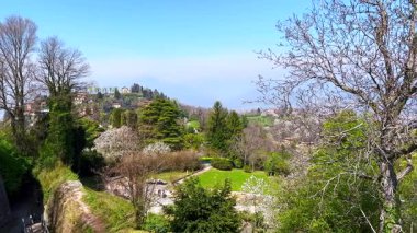 San Vigilio Kalesi 'nin ortaçağ harabelerinin tepesinden yeşil Monte Bastia, yeşil parklar, çiçek açan bahçeler ve Bergamo Alpleri, İtalya