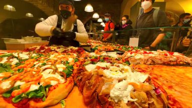 Üzerinde domates, prosciutto, mozzarella, fesleğen, ançüez, zeytin ve İtalya 'nın Bergamo Alta meyhanesindeki diğer malzemeler bulunan Focaccia tezgahı.