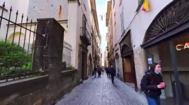 Bergamo 'nun Citta Alta' daki (Yukarı Şehir) dar gölgeli Via Bartolomeo Colleoni caddesi, uzun konaklar, küçük dükkanlar ve restoranlar, İtalya