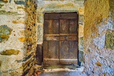 İsviçre 'nin Comano köyünde eski bir köy ve aşınmış ahşap bir kapı.