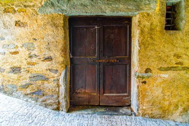 İsviçre 'nin Comano köyünde eski bir köy ve aşınmış ahşap bir kapı.