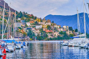 Lugano, İsviçre 'de tekne ve alp manzaralı liman sahnesi