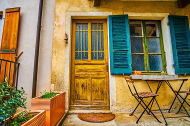 Komano, Ticino, İsviçre 'de küçük bir masa ve pencere ayarı ile aksanlı otantik konut kapısı