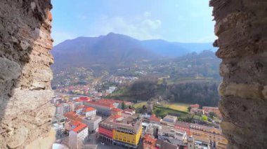 Beyaz Castelgrande Kulesi 'nin küçük taş penceresi Alp manzarası, kiremit çatılar ve renkli binalar Bellinthe, Ticino, İsviçre' nin manzarasını açar.