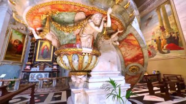 Bellinzona 'daki Collegiate Church' ün yontulmuş başyapıtı, taş işlemeli ve yaldızlı çelenklerle süslenmiş, İsviçre