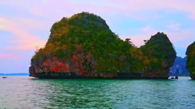 Andaman Denizi suları, Ao Nang, Krabi, Tayland, Railay Yarımadası 'ndaki kayaların üzerindeki mor alaca karanlık gökyüzü.