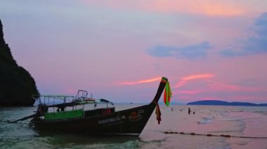 AO NANG, THAILAND - 26 Nisan 2019: Railay Sahili üzerinde güzel mor gün batımı (Rai Leh) ahşap uzun kuyruklu tekne silueti, renkli çizgilerle süslenmiş, 26 Nisan 'da Ao Nang