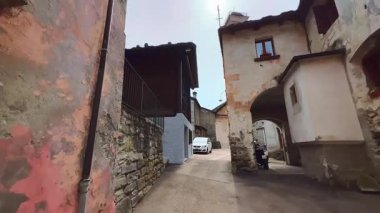 Prato Sornico 'nun dar sokaklarında ortaçağ taş evleri ve arka planda San Martino Kilisesi, Val Lavizzara, Vallemaggia, İsviçre