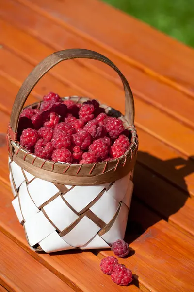 Verse frambozen in een mand op houten tafel — Stockfoto