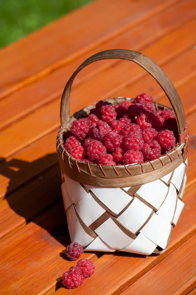 Verse frambozen in een mand op houten tafel — Stockfoto