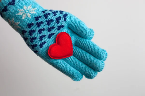 Rotes Herz in der Hand im warmen Handschuh zum Valentinstag — Stockfoto