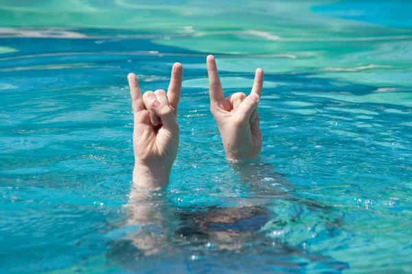 Two hands out of water in rock gesture — Stock Photo, Image