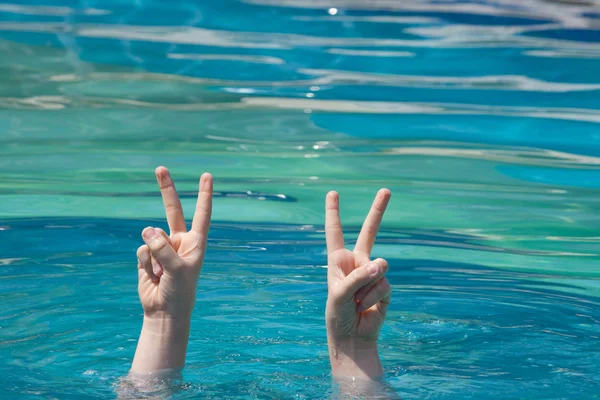 Two hands out of water in victory gesture — Stock Photo, Image